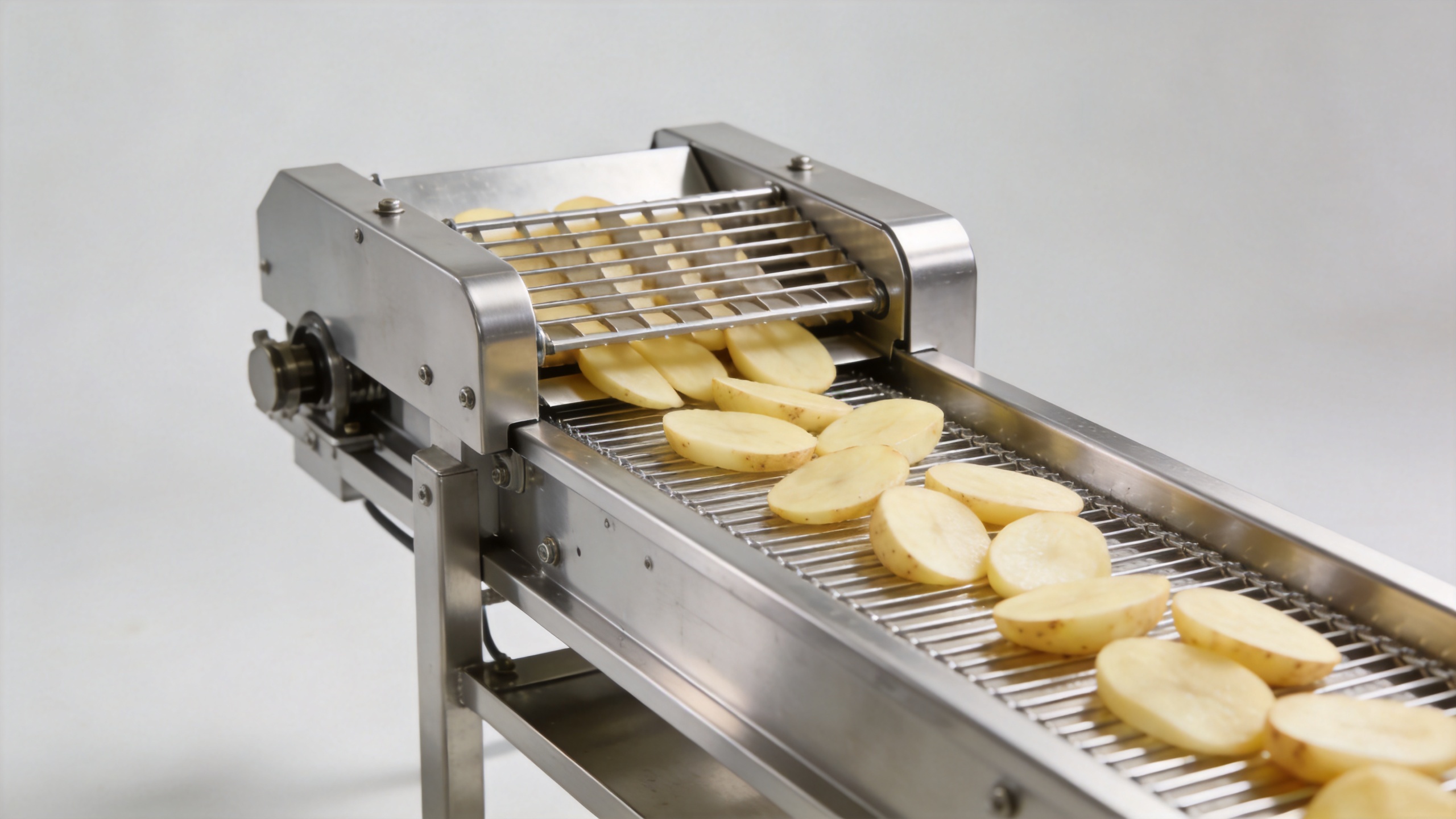 Commercial potato chip slicer with uniform potato slices on a hygienic conveyor