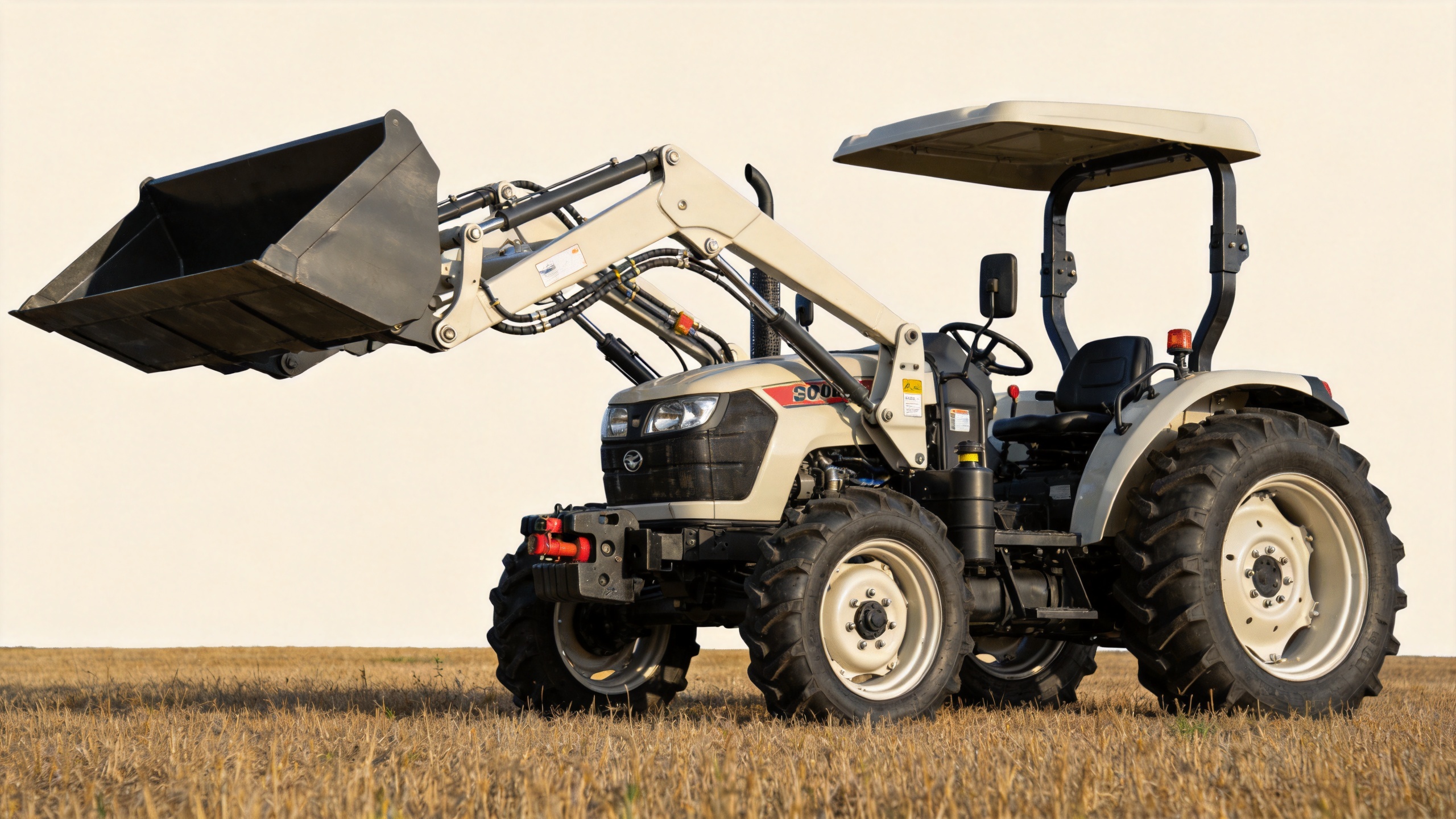 Compact diesel tractor with front loader attachment showing hydraulic connections and PTO shaft