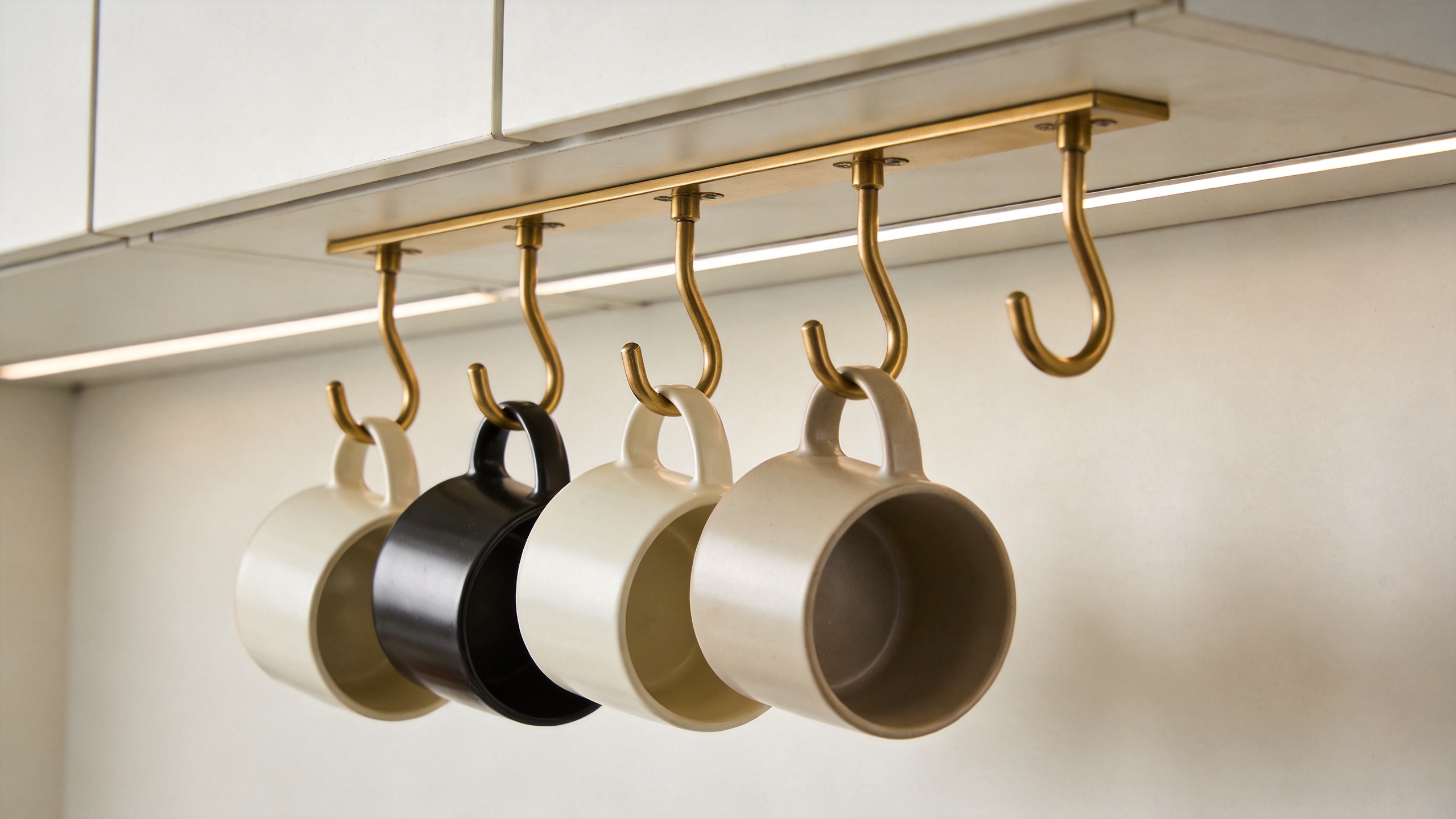 Cup hooks installed under kitchen cabinet holding coffee mugs in an organized storage setup