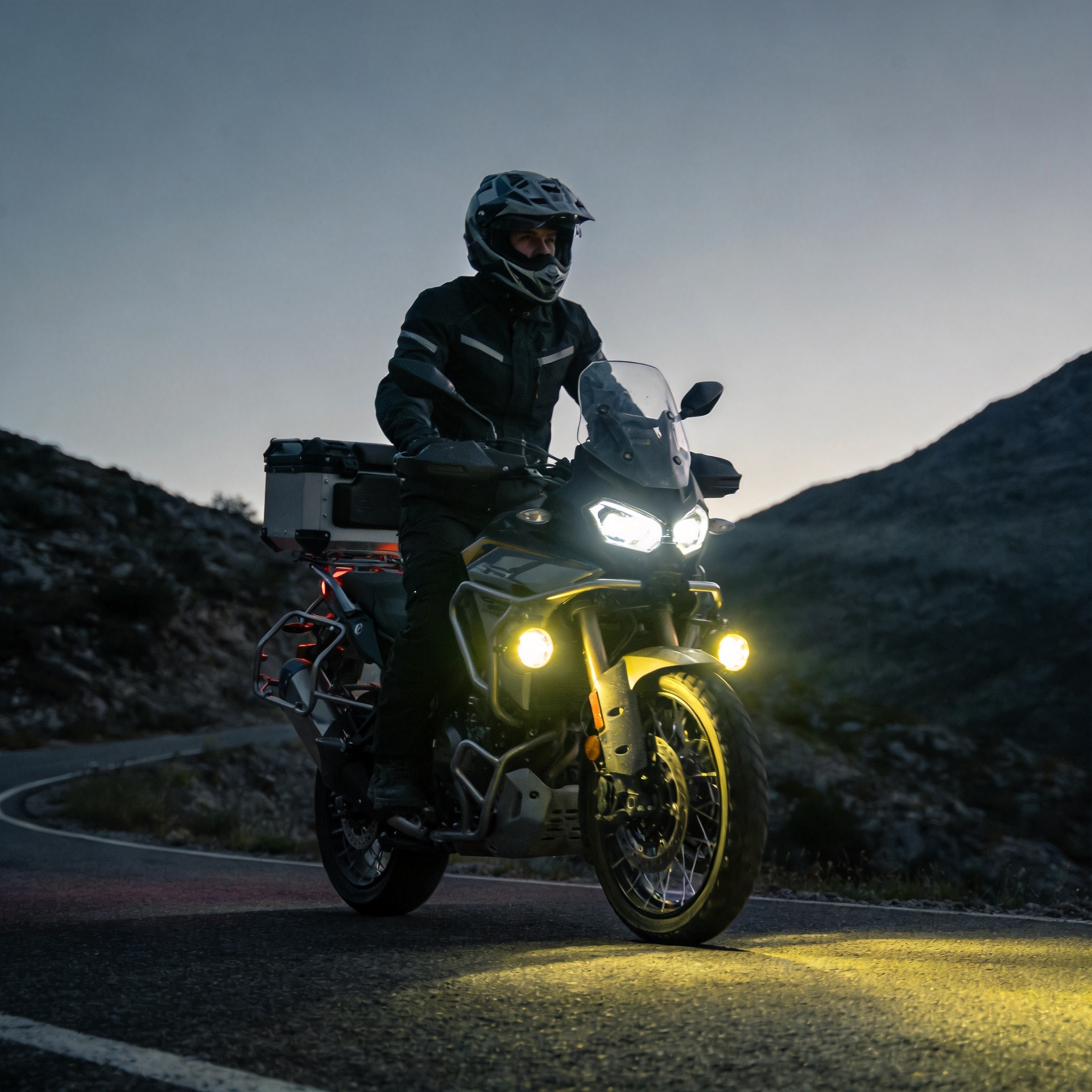 Adventure motorcycle on mountain road at night with LED aux lights for bikes illuminating the trail